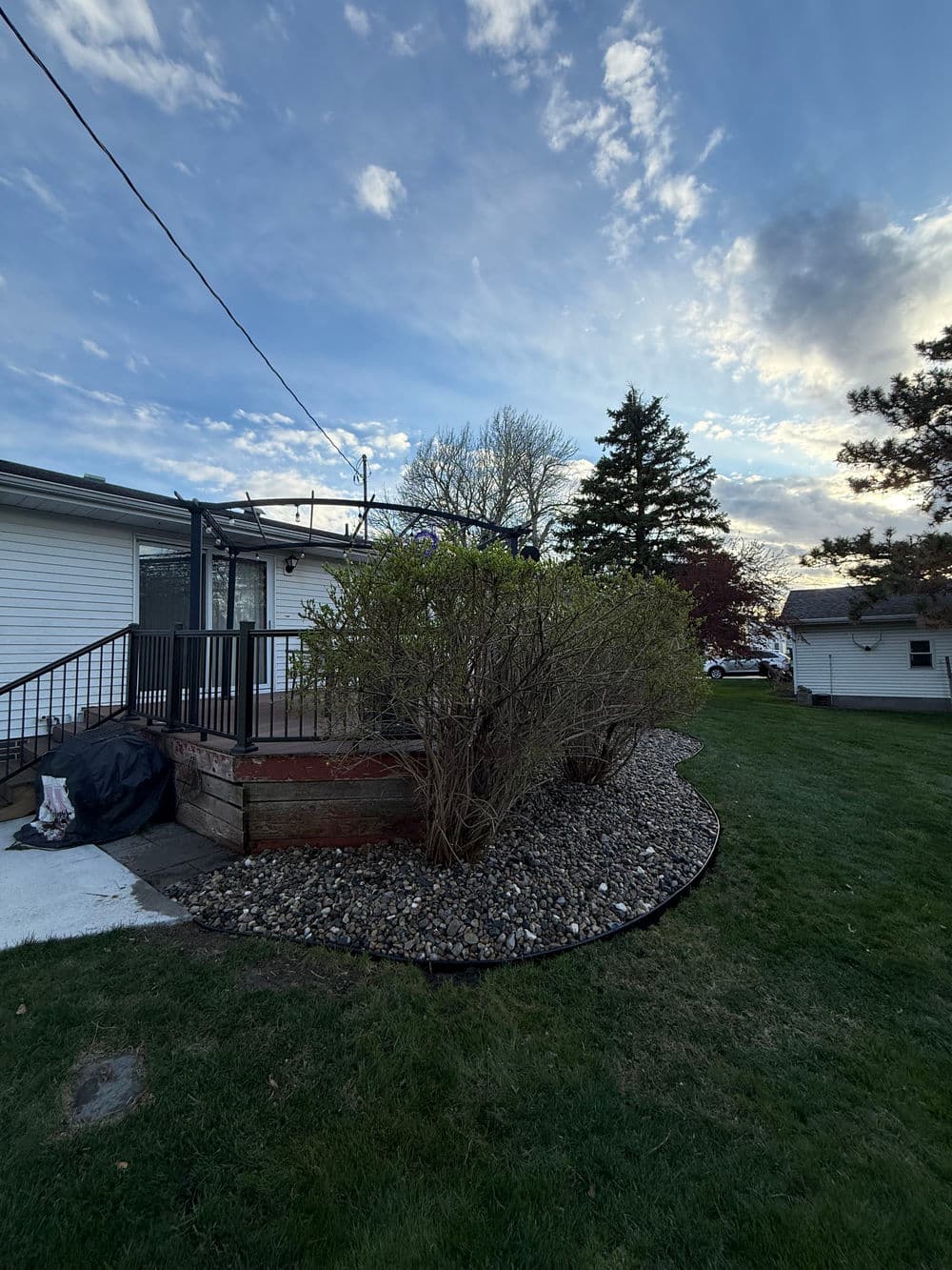 House exterior with landscaped garden, blue sky, and scattered clouds at dusk.